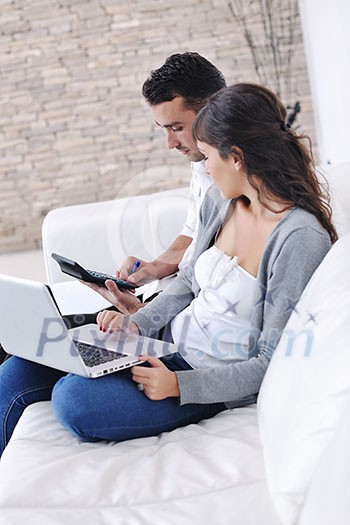 joyful couple relax and work on laptop computer at modern living room indoor home