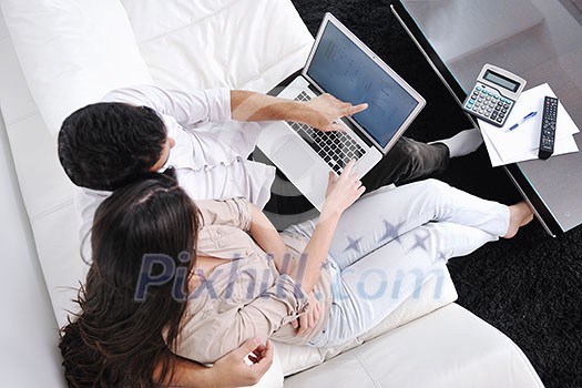 joyful couple relax and work on laptop computer at modern living room indoor home joyful couple relax and work on laptop computer at modern living room indoor home