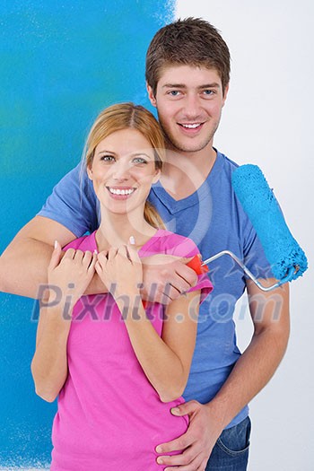 happy young couple paint in green and blue color white wall of their new home happy young couple paint in green and blue color white wall of their new home