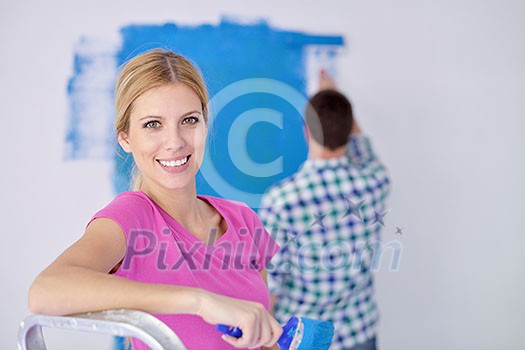 happy young couple paint in green and blue color white wall of their new home happy young couple paint in green and blue color white wall of their new home