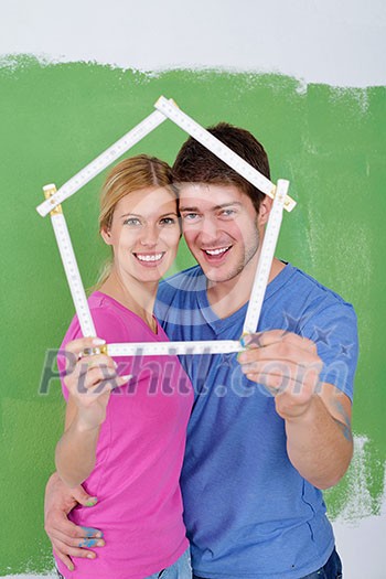 happy young couple paint in green and blue color white wall of their new home happy young couple paint in green and blue color white wall of their new home