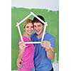 happy young couple paint in green and blue color white wall of their new home