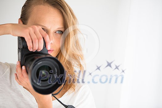 Pretty, female photographer with digital camera - DSLR and a huge telephoto lens (color toned image; shallow DOF) Pretty, female photographer with digital camera - DSLR and a huge telephoto lens (color toned image; shallow DOF)