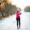 Winter running - Young woman running outdoors on a cold winter day