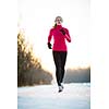 Winter running - Young woman running outdoors on a cold winter day