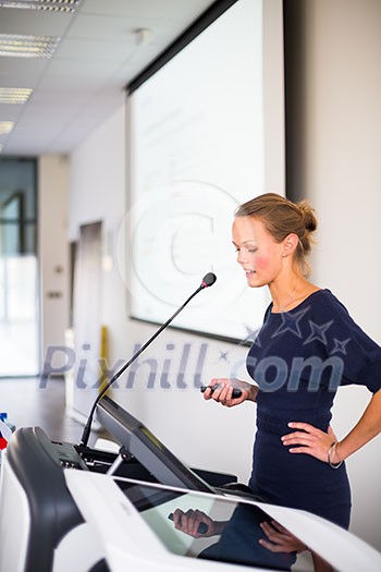 Pretty, young business woman giving a presentation in a conference/meeting setting (shallow DOF; color toned image)