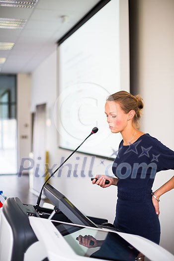 Pretty, young business woman giving a presentation in a conference/meeting setting (shallow DOF; color toned image) Pretty, young business woman giving a presentation in a conference/meeting setting (shallow DOF; color toned image)