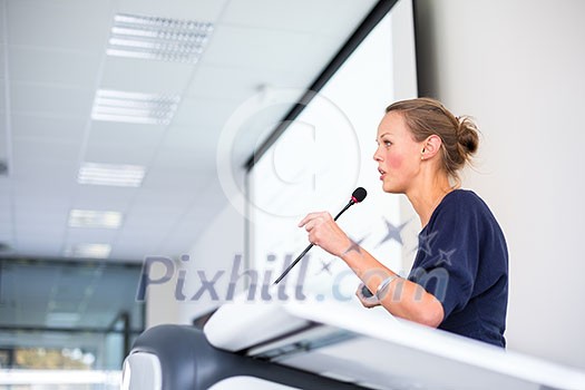 Pretty, young business woman giving a presentation in a conference/meeting setting (shallow DOF; color toned image) Pretty, young business woman giving a presentation in a conference/meeting setting (shallow DOF; color toned image)