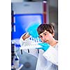 Young male researcher carrying out scientific research in a lab (shallow DOF; color toned image)