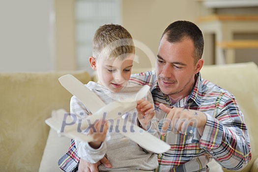 father and son assembling airplane toy at modern home living room indoor
