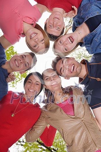 Happy smiling group of young friends staying together outdoor in the park