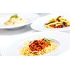 Italian spaghetti topped with bolognaise, or bolognese, sauce with tomatoes, meat and cheese on a plain white plate