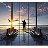 Businessman at airport looking at airplane taking off