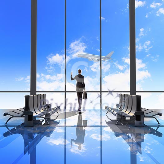 Image of woman in airport looking at taking off airplane Image of woman in airport looking at taking off airplane