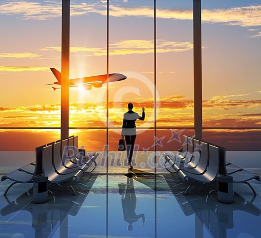 Image of woman in airport looking at taking off airplane Image of woman in airport looking at taking off airplane
