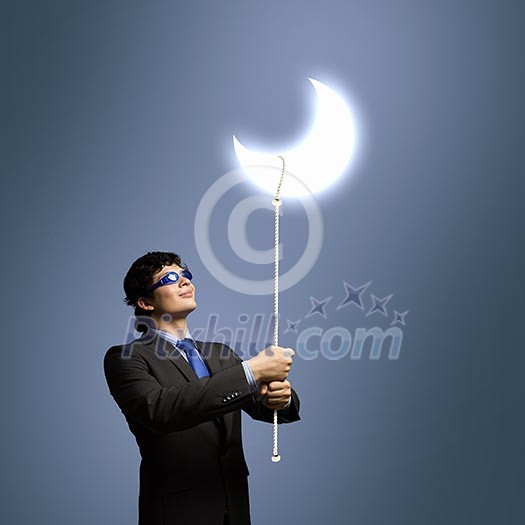 Image of young businessman in goggles looking at moon