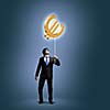 Image of businessman catching euro symbol. Currency concept