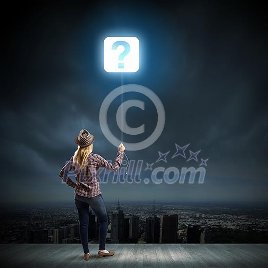 Young woman in casual holding balloon shaped like question mark Young woman in casual holding balloon shaped like question mark