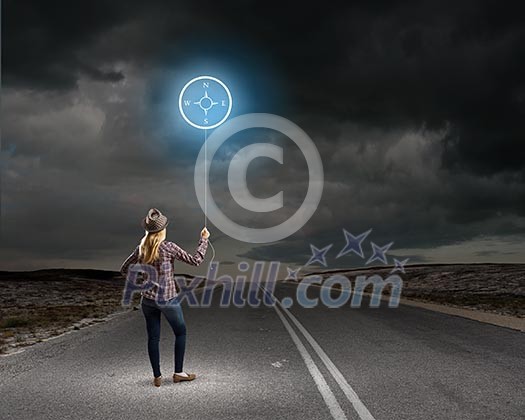 Rear view of woman in casual holding balloon in hand Rear view of woman in casual holding balloon in hand