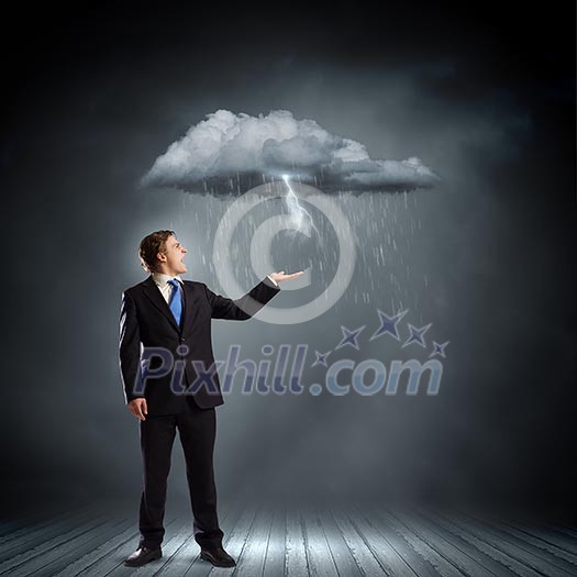 Young businessman under raining sky. Failure concept