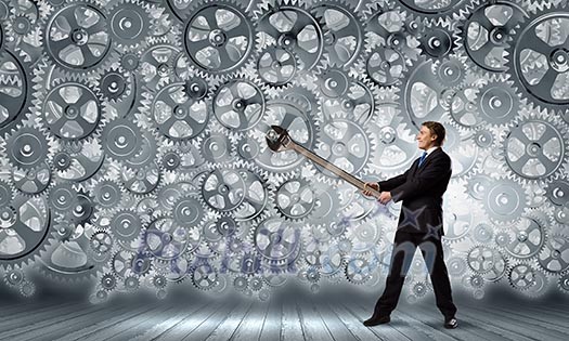 Young businessman fixing gears mechanism with wrench Young businessman fixing gears mechanism with wrench