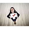 Top view of businesswoman holding white banner with red tick