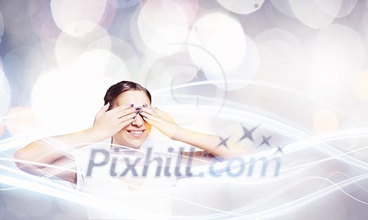 Young woman in casual hiding eyes behind palms Young woman in casual hiding eyes behind palms