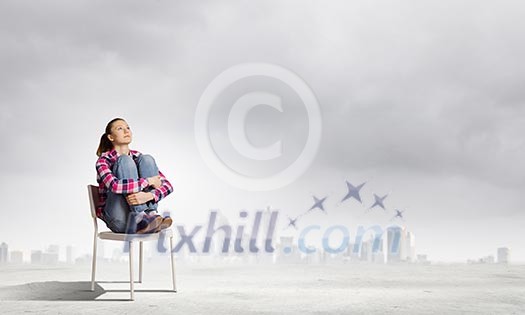 Young girl sitting in chair against city background