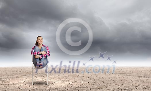Young woman sitting in chair among desert Young woman sitting in chair among desert