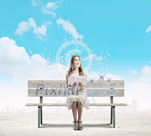 Young pretty asian woman sitting on bench and reading book Young pretty asian woman sitting on bench and reading book