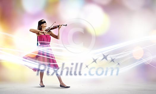 Young attractive woman in red dress playing violin