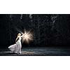 Young woman in white long dress walking in night wood