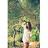 Attractive, young brunette on the beach, amid olive trees, looking both sensual and natural