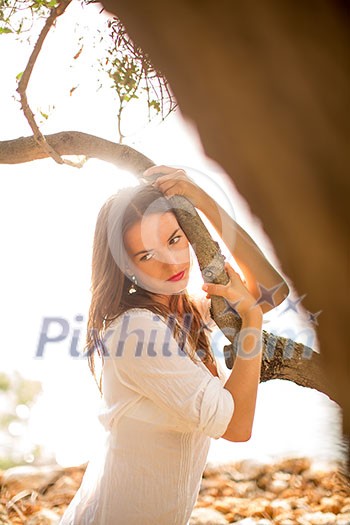 Attractive, young brunette on the beach, amid olive trees, looking both sensual and natural Attractive, young brunette on the beach, amid olive trees, looking both sensual and natural