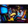 happy father and son playing driving wheel video game in playground theme park