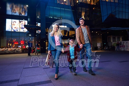 happy family walking with paper bag in front of  shopping mall