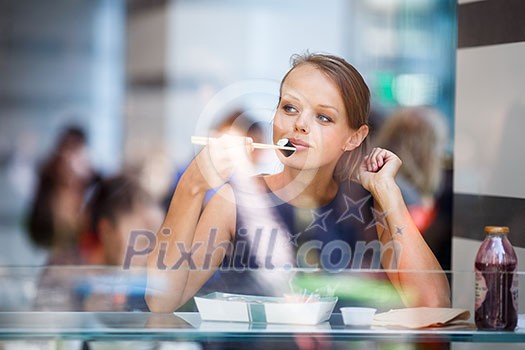 Pretty, young womna eating sushi in a restaurant, haivng her lunch break, enjoying the food, pausing for a while from her busy corporate/office life (color toned image) Pretty, young womna eating sushi in a restaurant, haivng her lunch break, enjoying the food, pausing for a while from her busy corporate/office life (color toned image)