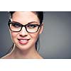 Portrait of a smiling pretty, young woman wearing glasses with copy space - studio shot, color toned