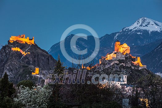 Switzerland, Valais, Sion, Night Shot of the two Castles - Tourbillon castle on the left and the fortified basilica of Valere is on the hill to the right Switzerland, Valais, Sion, Night Shot of the two Castles - Tourbillon castle on the left and the fortified basilica of Valere is on the hill to the right
