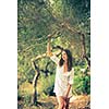 Attractive, young brunette on the beach, amid olive trees, looking both sensual and natural