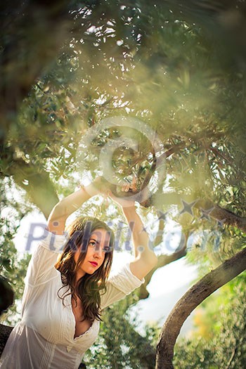 Attractive, young brunette on the beach, amid olive trees, looking both sensual and natural Attractive, young brunette on the beach, amid olive trees, looking both sensual and natural
