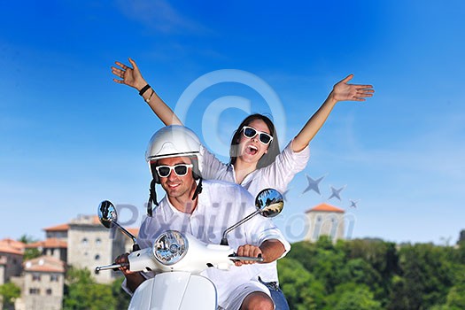 Portrait of happy young love couple on scooter enjoying themselves in a park at summer time Portrait of happy young love couple on scooter enjoying themselves in a park at summer time