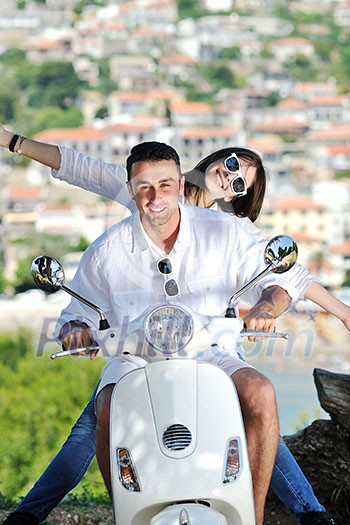 Portrait of happy young love couple on scooter enjoying themselves in a park at summer time Portrait of happy young love couple on scooter enjoying themselves in a park at summer time
