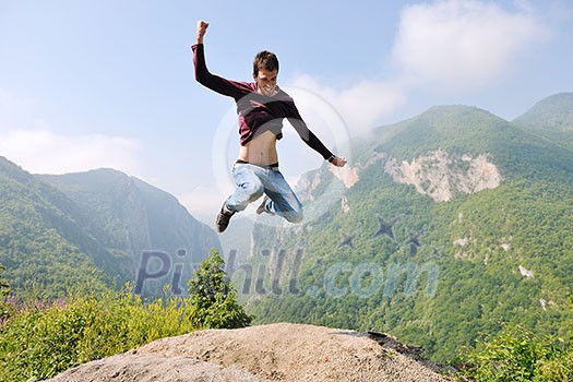 happy young man jump in nature while representing healthy lifestyle freedom and active concept