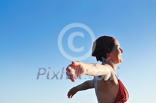 happy girl spreading hands and enjoy in sunlight at summer vacation