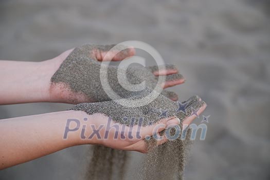 fine sand leaking trought woman hands fine sand leaking trought woman hands
