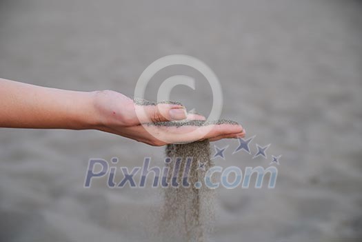 fine sand leaking trought woman hands fine sand leaking trought woman hands