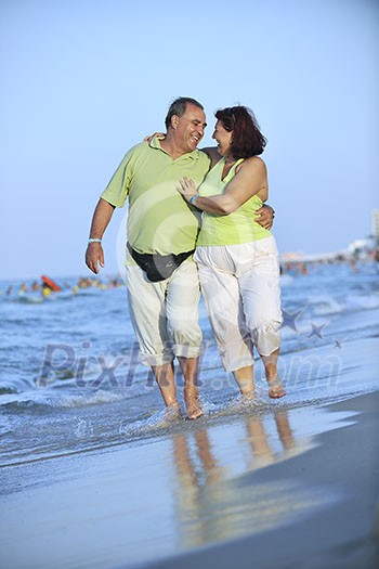 happy senior mature elderly people couple have romantic time on beach at sunset 