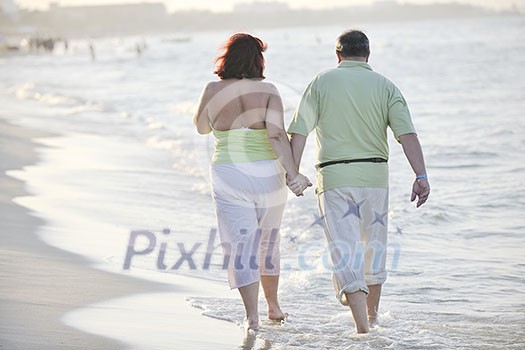 happy senior mature elderly people couple have romantic time on beach at sunset 