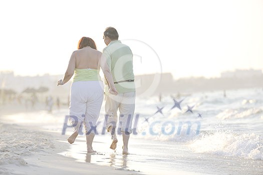 happy senior mature elderly people couple have romantic time on beach at sunset 